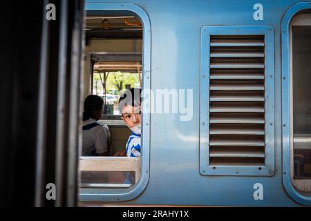 Enfant voyageant sur les chemins de fer thaïlandais de la gare de Hua Lamphong à Bangkok Banque D'Images