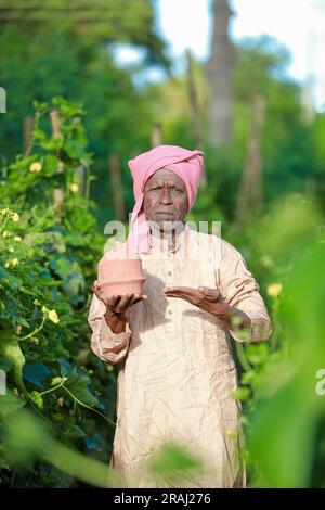 Agriculture indienne bon agriculteur tenant une banque de porc dans la ferme, pauvre agriculteur, fermier épargnant Banque D'Images