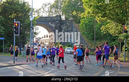 Les membres du Victoria Park Running Club Warrington, passage en groupe de course du soir à 752a Knutsford Rd, Warrington, Cheshire, Angleterre, Royaume-Uni, WA4 1JS Banque D'Images