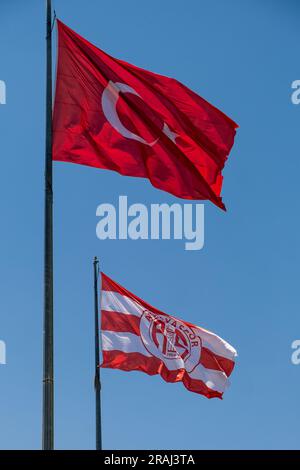 Drapeau turc agitant dans le ciel, devant un fond bleu Banque D'Images