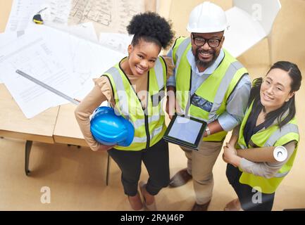 Tablette, travail d'équipe ou portrait d'ingénieurs avec un concepteur planifiant une construction pour l'architecture. Vue de dessus, plan ou heureux Noirs avec asiatique Banque D'Images