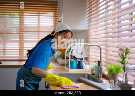 Gardien de la maison nettoyer la cuisine. Service de nettoyage et concept d'entretien de la maison. Banque D'Images