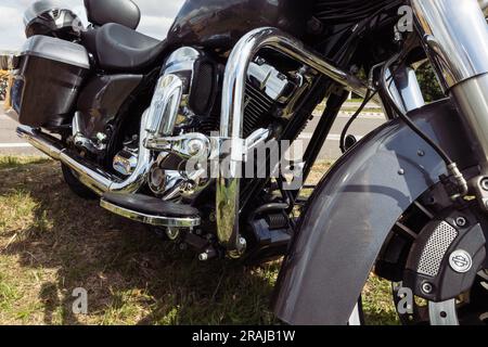 vue latérale de moto noire gros plan, moto debout sur l'herbe verte isolée, vue rapprochée. Photo de haute qualité Banque D'Images