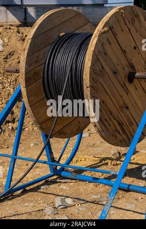 Bobines en bois de câble électrique extérieur. Câbles haute et basse tension. bobines de fils industriels. Rouleau de câbles blindés pour signaux à fibres optiques extérieurs. Bobines Banque D'Images