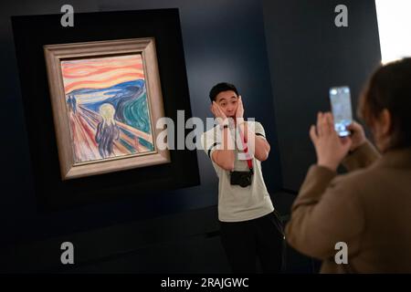 Oslo, Norvège, 20 juin 2023: Les touristes observent la célèbre composition d'Edvard Munch la crème au Musée Munch. Les visiteurs prennent des photos imitant la fa Banque D'Images