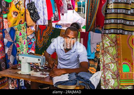 Un homme avec une vieille machine à coudre et du tissu sur le marché de Praia, île de Santiago, îles du Cap-Vert Banque D'Images