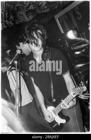 ELASTICA, YOUNG, EARLY GIG, 1994 : Justine Frischmann d'Elastica jouant un concert chaotique très tôt au légendaire TJS à Newport, pays de Galles, Royaume-Uni le 23 février 1994. Photo : Rob Watkins. INFO : Elastica, un groupe de rock alternatif britannique formé en 1992, est acclamé avec leur premier album éponyme. Des hits comme 'Connection' ont présenté leurs influences post-punk et New wave. Dirigée par Justine Frischmann, la contribution d'Elastica à l'ère Britpop est significative. Banque D'Images