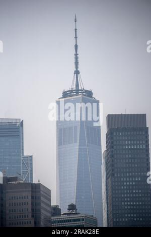 World Trade Center vu à travers la brume fumée de l'autre côté du port de New York samedi, 1 juillet 2023. La fumée des feux de forêt canadiens se propage vers le sud dans tout le Nord-est, ce qui entraîne des problèmes de qualité de l'air malsains Banque D'Images