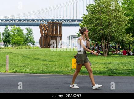 Le « TERRAIN » de Nicholas Galanin est exposé dans le Brooklyn Bridge Park à Brooklyn, à New York, vu samedi, 1 juillet 2023. La sculpture massive de 30 pieds utilise le même acier que celui utilisé pour construire les États-Unis Mur frontalier mexicain qui évoque la « TERRE » évocatrice de la sculpture D'AMOUR de Robert Indiana (© Richard B. Levine) Banque D'Images