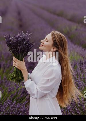 Femme tenant bouquet dans Blooming Lavender Field Banque D'Images