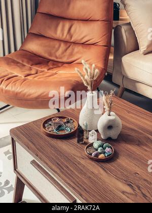 Vases décoratifs en pierre de lave avec fleurs sèches et cristaux de guérison sur la table dans la salle de séjour à proximité Banque D'Images