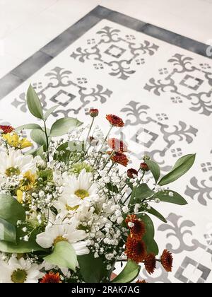 Bouquet de chrysanthèmes de différentes couleurs dans un vase à l'intérieur du salon en gros plan Banque D'Images