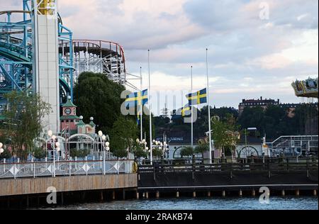 Un parc d'attractions Gröna Lund vide et déserté à Stockholm, en Suède, est toujours fermé après le tragique accident de la semaine dernière, lorsqu'une femme est décédée et que neuf personnes ont été blessées sur les montagnes russes Jetline. Sur la photo : les drapeaux suédois sont vus ici à mi-mât dans le parc d'attractions. Banque D'Images