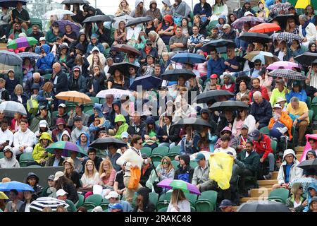 Londres, Royaume-Uni. 04th juillet 2023. Les spectateurs ont mis leurs parapluies pendant que des arrêts de pluie jouent le deuxième jour des championnats de Wimbledon 2023 à Londres, mardi, 04 juillet 2023. Photo de Hugo Philpott/UPI crédit: UPI/Alay Live News Banque D'Images