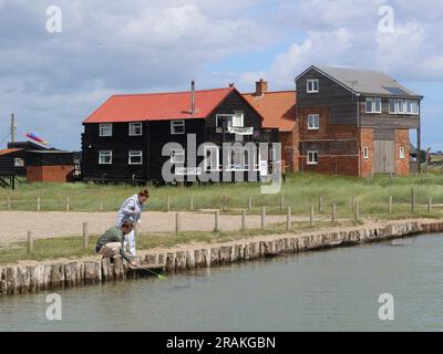 Walberswick, Suffolk - 3 juillet 2023 : chaud après-midi d'été sur la côte anglaise. Deux personnes pêchant le crabe. Banque D'Images