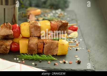 La viande est cuite sur des brochettes sur un feu ouvert. Viande et légumes sur de longues et fines brochettes en bambou ou en métal, sur un feu ouvert ou sur un gril Banque D'Images