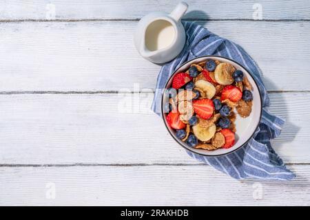 Petit déjeuner d'été diététique vitaminique sain. Céréales flocons multigrains avec yaourt ou lait et fraises, myrtilles, sur l'espace de copie de table de cuisine Banque D'Images
