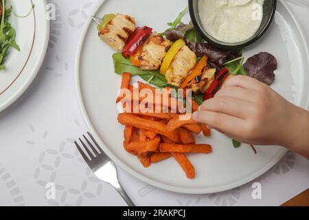 Souvlaki grec, potatoe sucré et sauce au yaourt tzatziki servis dans l'assiette du restaurant Banque D'Images