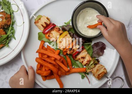 Souvlaki grec, potatoe sucré et sauce au yaourt tzatziki servis dans l'assiette du restaurant Banque D'Images