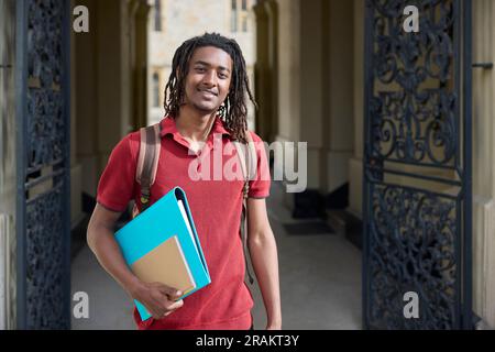 Portrait d'un étudiant portant des dossiers à l'extérieur du bâtiment de l'université d'Oxford, au Royaume-Uni Banque D'Images