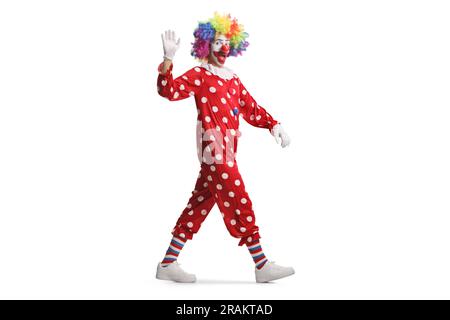 Prise de vue en longueur d'un clown en costume rouge marchant et agitant isolé sur fond blanc Banque D'Images