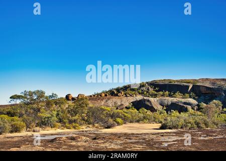 Roches érodées et rochers avec végétation de l'outback raboutée dans la réserve naturelle de Sandford Rocks, un affleurement granitique près de Westonia, en Australie occidentale. Banque D'Images