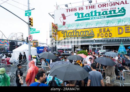 Brooklyn, NY, États-Unis, 4 juillet 2023, les foules se rassemblent et cherchent refuge contre les fortes pluies à Brooklyn, NY, États-Unis alors que le concours annuel de restauration de hot-dogs de Nathan à Coney Island a été repoussé en raison du mauvais temps le 4 juillet 2023 Banque D'Images