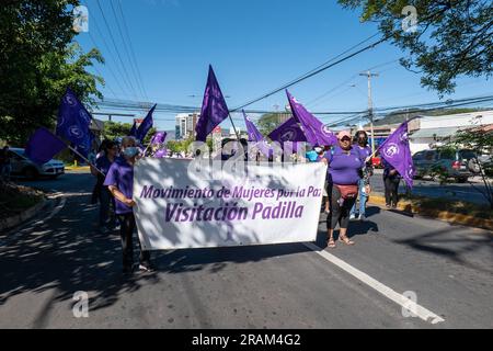 Tegucigalpa, Honduras - 25 novembre 2022 : plusieurs femmes avec des drapeaux violets et un signe qui dit : 'mouvement des femmes pour la paix' marche sur l'International D. Banque D'Images