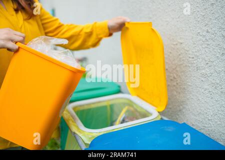 jeune femme jette le sac poubelle dans les déchets de tri de déchets, femme en tenue décontractée, personne écologique sauver la planète, environnement par la pollution Banque D'Images