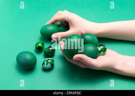 Mains femelles tenant des œufs de caille de poulet de Pâques bleu vert sur fond bleu. Pascha ou Dimanche de la Résurrection, fête chrétienne et fête culturelle Banque D'Images