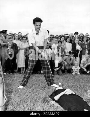 Base aérienne d'Offutt, Nebraska : 1951. Le golfeur de stunt Paul Hahn se prépare à chasser une balle d'un tee tenu dans la bouche de sa femme, Bobbie. Banque D'Images