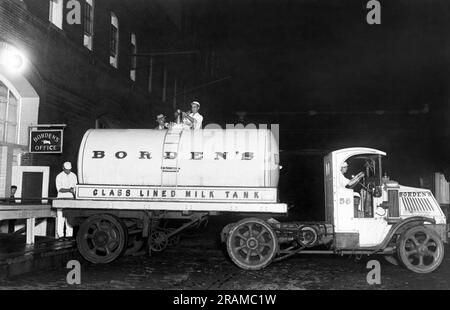 New York, New York: c. 1928 Un nouveau camion de lait de Borden avec le dernier en matière de transport de lait. Le chariot est équipé d'un récipient en verre sans couture recouvert de liège qui maintient le lait à 37 degrés for16 heures sans glace. Il suffit à un homme de dix minutes pour charger le réservoir du camion de 8000 pintes du réservoir du train, par opposition à l'ancienne méthode avec trois hommes prenant 45 minutes pour charger 200 boîtes de lait. Ici, le camion à lait « bouteille sous vide » déchargeant le lait à l'usine de pasteurisation. Banque D'Images