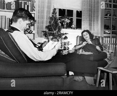 Etats-Unis: 5 décembre 1941 Un mari et une femme sont installés pour une soirée d'hiver tranquille de lecture et de tricotage. Banque D'Images