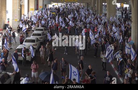 Les manifestants anti-gouvernementaux brandisquent des drapeaux israéliens lorsqu'ils se rassemblent à l'extérieur du principal aéroport international d'Israël lors d'une manifestation contre le PM Benjamin Netanyahu et le plan de la droite dure du système judiciaire gouvernemental d'Israël qui vise à affaiblir la Cour suprême du pays, à l'aéroport Ben Gourion près de tel Aviv sur 3 juillet 2023 à Lod, en Israël. Banque D'Images