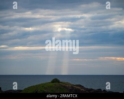 Des rayons de soleil célestes qui brillent vers l'océan depuis les nuages, ressemblant un peu à une invasion extraterrestre, me téléportent Banque D'Images