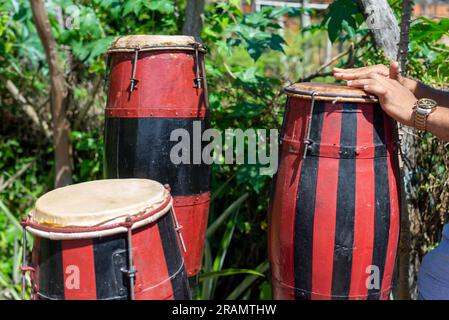 Mains d'un musicien debout immobile sur un atabaque brésilien. Acupe, Santo Amaro, Bahia. Banque D'Images