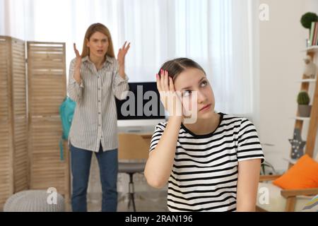 Fille adolescente ignorant sa mère alors qu'elle la grondait à la maison Banque D'Images