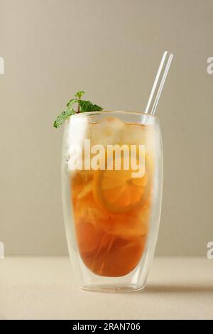 Thé au citron froid sur grand verre à double paroi, garniture de feuilles de menthe. Thé au citron es avec espace de copie pour le texte Banque D'Images