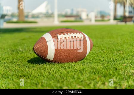 Ballon de football américain sur gazon. Vue rapprochée avec arrière-plan non mis au point. Banque D'Images