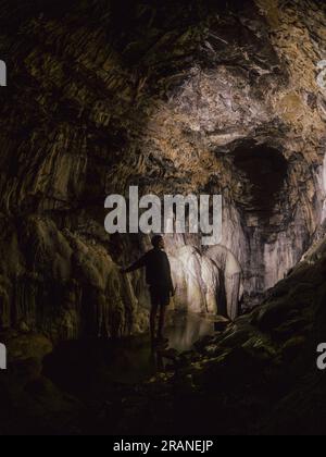 Homme explorant la beauté mystérieuse et naturelle de Spar Cave sur l'île de Skye, en Écosse, dans un voyage souterrain captivant Banque D'Images