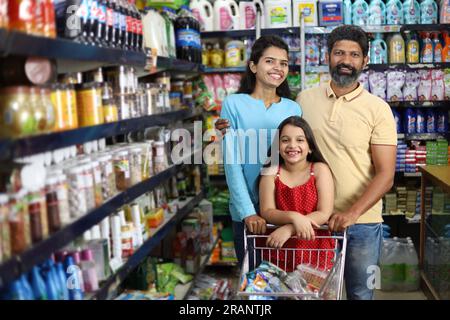 shopping familial heureux dans l'épicerie et le supermarché. Ils recherchent les produits désirés dont ils ont besoin pour acheter. Banque D'Images