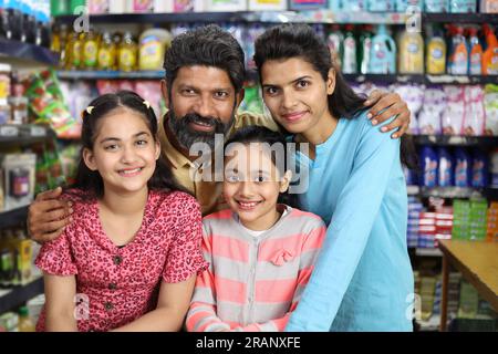 shopping familial heureux dans l'épicerie et le supermarché. Ils recherchent les produits désirés dont ils ont besoin pour acheter. Banque D'Images