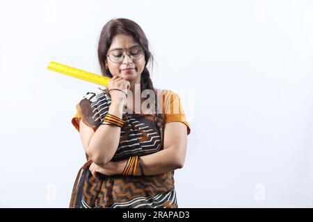 Femme heureuse indienne rurale enseignante dans le village tenant l'échelle jaune, portant Saree et spectacle dépeignant diverses expressions de la vie de l'enseignant. Banque D'Images