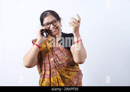 Vieille femme indienne rurale portant Saree représentant diverses expressions au téléphone. Elle tient un téléphone portable. Go Digital concept dans l'Inde rurale. Banque D'Images