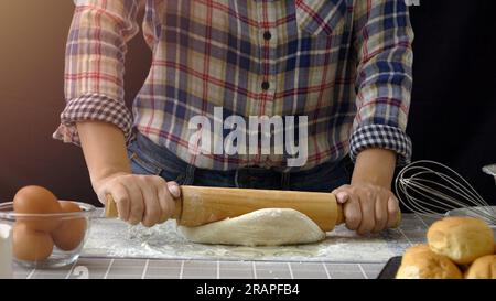 Pain artisanal travaillant avec de la pâte. Saupoudrage de farine sur la pâte, pâte à pain à la main roulant et pétrissant dans la cuisine avec des outils d'équipement de boulangerie Banque D'Images