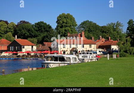 Une vue du Rising Sun Inn avec des bateaux amarrés près de la rivière Bure sur les Norfolk Broads à Coltishall, Norfolk, Angleterre, Royaume-Uni. Banque D'Images