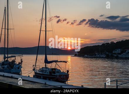 Yacht au coucher du soleil Milna village et port sur la côte ouest de l'île de Brac Croatie dans la mer Adriatique sur le comté de Split-Dalmatie. Banque D'Images