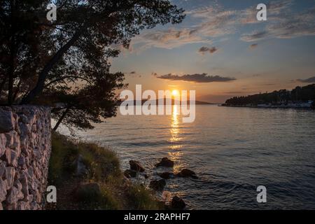 Coucher de soleil Milna village et port sur la côte ouest de l'île de Brac Croatie dans la mer Adriatique sur le comté de Split-Dalmatie. Banque D'Images