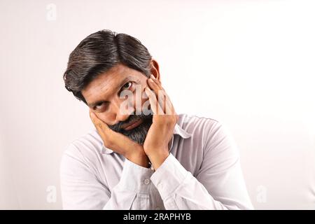 Portrait d'un barbu indien portant une chemise. Expressions funky tristes et déprimées pleines de tristesse et de regrets. Banque D'Images