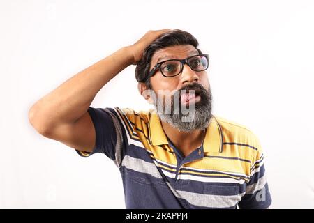 Portrait d'un barbu indien portant des spécifications et un t-shirt. Les expressions funky ont déformé le visage. Homme étonné montrant diverses humeurs de personnalité farfelue. Banque D'Images